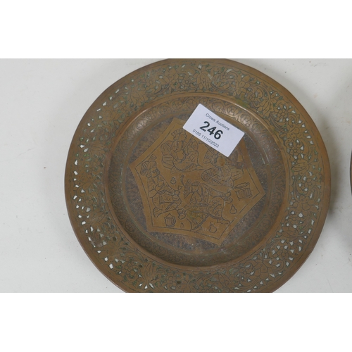 246 - A pair of Indian/Persian brass dishes with pierced rims and engraved decoration of men feasting and ... 