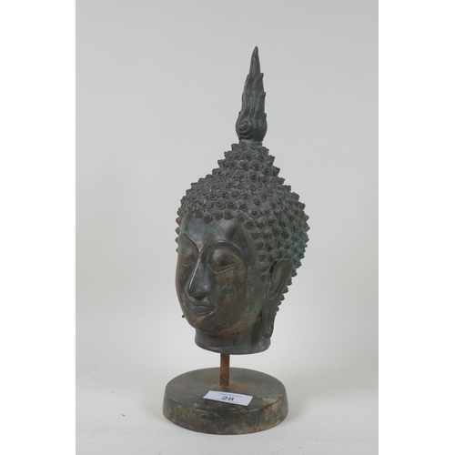 28 - A bronze Buddha's head mounted on a metal stand, 32cm high