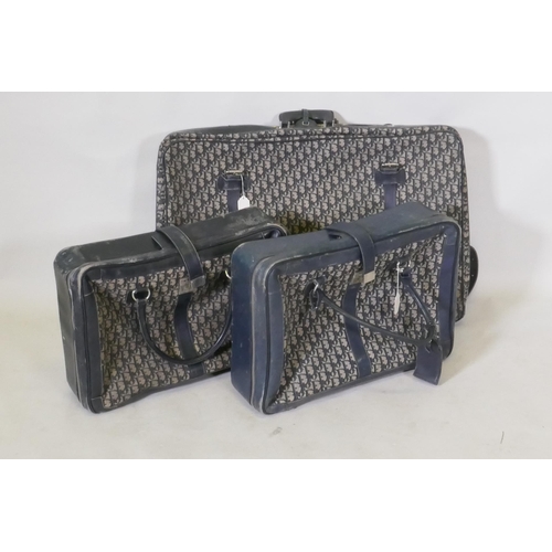 293 - Christian Dior, three vintage fabric and blue leather suitcases, c.1970s, 75 x 50 x 15cm