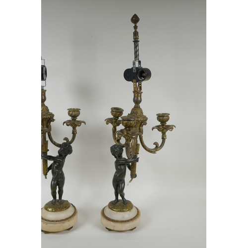 32 - A pair of bronze and ormolu cherub three branch candlesticks converted to a lamp, 60cm high