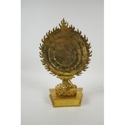 40 - A Tibetan gilt bronze figure of a many armed deity standing on a lotus flower, 32cm high