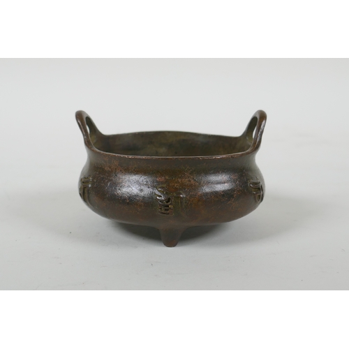 41 - A Chinese bronze censer with two handles, character decoration and tripod supports, impress Xuande 6... 