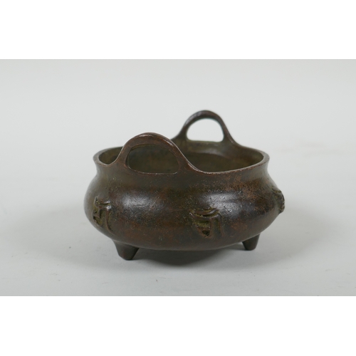 41 - A Chinese bronze censer with two handles, character decoration and tripod supports, impress Xuande 6... 