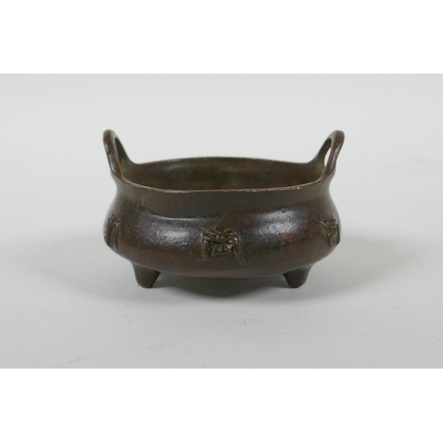 41 - A Chinese bronze censer with two handles, character decoration and tripod supports, impress Xuande 6... 