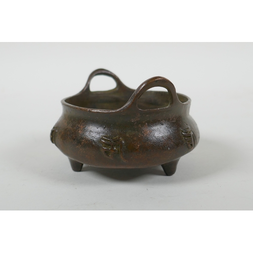 41 - A Chinese bronze censer with two handles, character decoration and tripod supports, impress Xuande 6... 