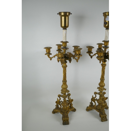 46 - A pair of French ormolu five branch candlesticks on a tripod base with griffin decoration, the centr... 