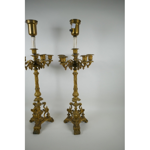 46 - A pair of French ormolu five branch candlesticks on a tripod base with griffin decoration, the centr... 