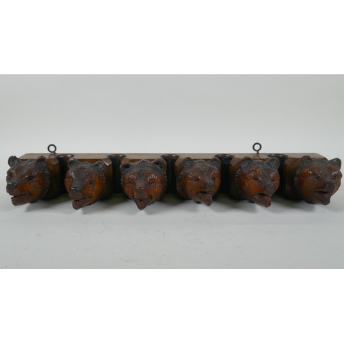 6 - An antique Black Forest carved wood pipe rack with bear's head decoration, a pair of turned wood tob... 