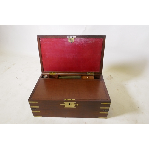 70 - A C19th mahogany campaign writing slope with brass mounts and military style carrying handles, the i... 