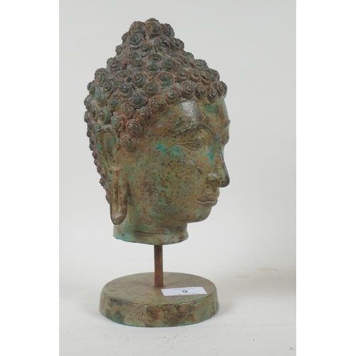 9 - A vintage bronze Buddha's head with green patination, mounted on a stand, 27cm