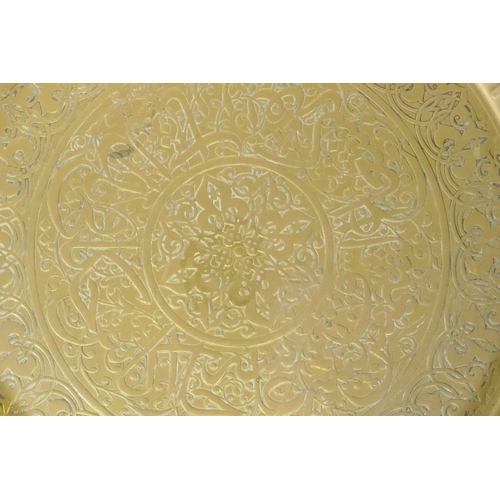 90 - An Islamic brass tray with script decoration, together with another larger decorated with Islamic sc... 