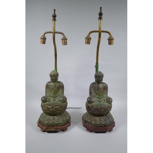 10 - A pair of Chinese bronze Buddha table lamps, with ver de gris patina and wood bases, 62cm high