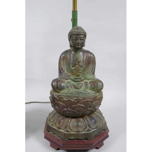 10 - A pair of Chinese bronze Buddha table lamps, with ver de gris patina and wood bases, 62cm high