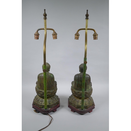 10 - A pair of Chinese bronze Buddha table lamps, with ver de gris patina and wood bases, 62cm high