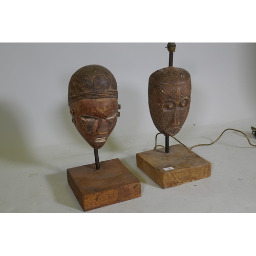 104 - Two antique African painted and carved wood masks, partially converted to lamps, 53cm high