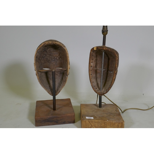 104 - Two antique African painted and carved wood masks, partially converted to lamps, 53cm high