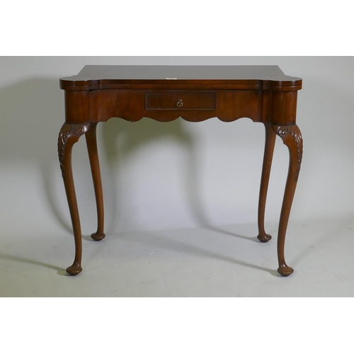 1067 - A George style walnut card table with shaped top and frieze, fitted with a single drawer, raised on ... 