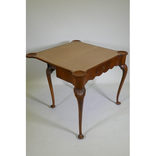 1067 - A George style walnut card table with shaped top and frieze, fitted with a single drawer, raised on ... 