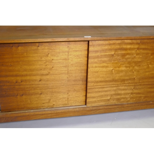 1071 - A mid century rosewood side cabinet with two slide doors, 125 x 46 x 65cm