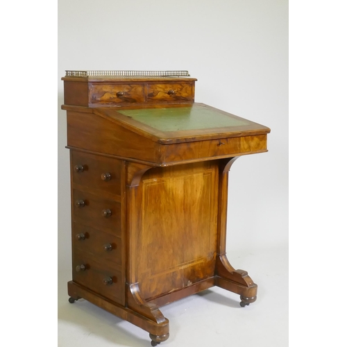 1077 - A Victorian inlaid figured walnut davenport, with pierced gallery over two drawers, one fitted with ... 