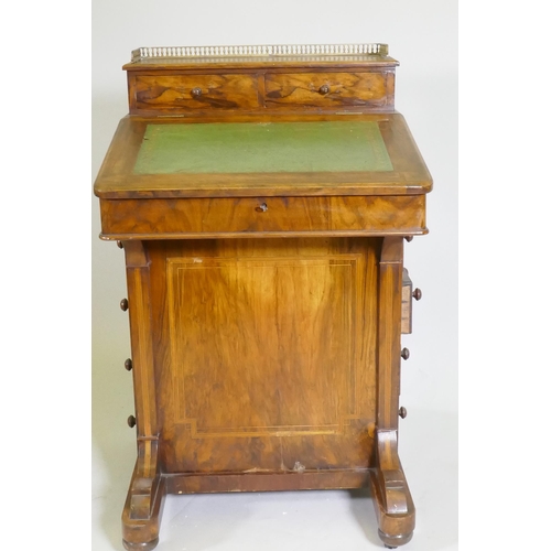 1077 - A Victorian inlaid figured walnut davenport, with pierced gallery over two drawers, one fitted with ... 