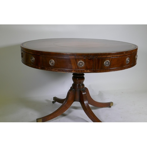 1083 - A C19th mahogany drum table, with inset gilt tooled leather top, four true and four false drawers, r... 