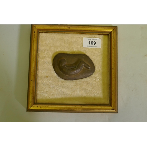 109 - A small bronze depicting a curled figure, signed with a monogram HR, 9cm long