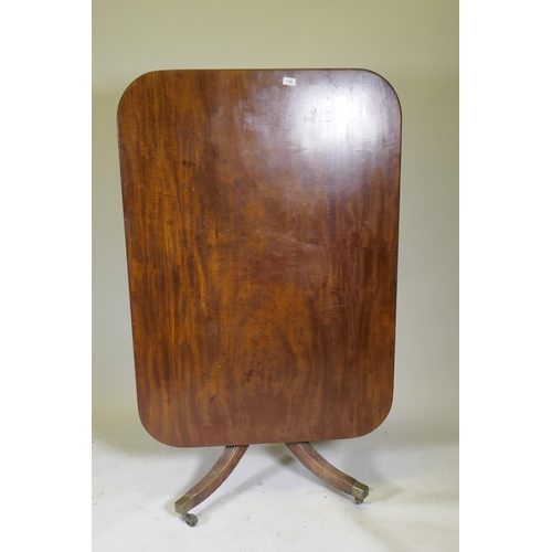 1100 - A Regency mahogany tilt top breakfast table, with single piece top and reeded edge, raised on turned... 