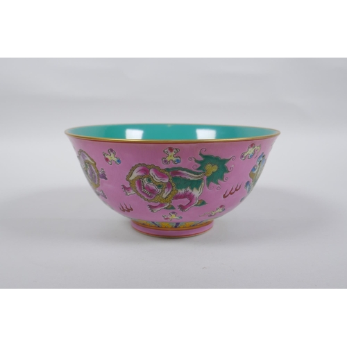 112 - A Chinese polychrome porcelain rice bowl, decorated with temple lions on a pink field, inscription t... 