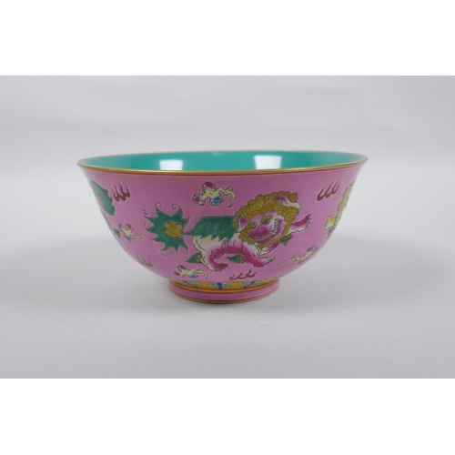 112 - A Chinese polychrome porcelain rice bowl, decorated with temple lions on a pink field, inscription t... 