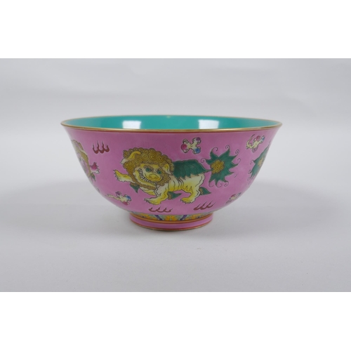 112 - A Chinese polychrome porcelain rice bowl, decorated with temple lions on a pink field, inscription t... 