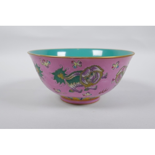 112 - A Chinese polychrome porcelain rice bowl, decorated with temple lions on a pink field, inscription t... 