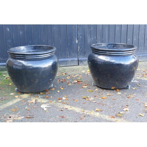 1124 - A pair of large black glazed ceramic garden pots, 59cm high, 70cm wide