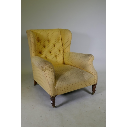 1143 - A Victoria deep back wing armchair, raised on on turned supports