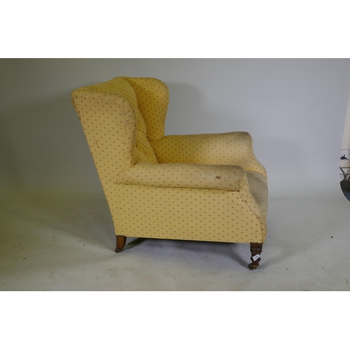 1143 - A Victoria deep back wing armchair, raised on on turned supports