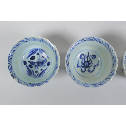 116 - Four Chinese Ming style blue and white porcelain tea bowls decorated with flowers, carp, figures and... 