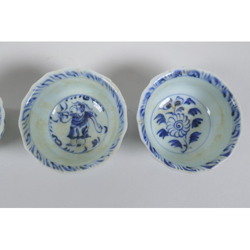 116 - Four Chinese Ming style blue and white porcelain tea bowls decorated with flowers, carp, figures and... 