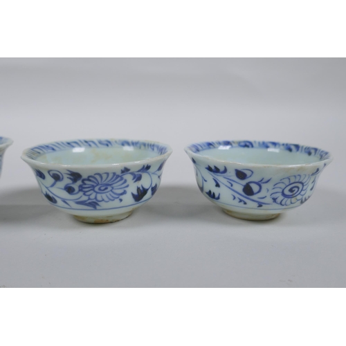 116 - Four Chinese Ming style blue and white porcelain tea bowls decorated with flowers, carp, figures and... 