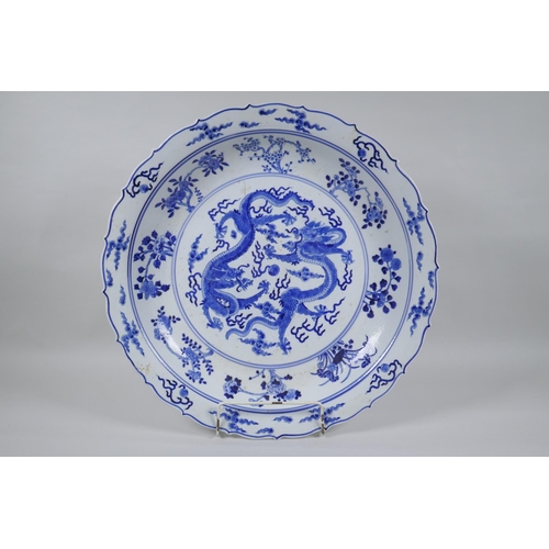 119 - A Chinese blue and white porcelain charger with lobed rim, decorated with two dragons chasing a flam... 