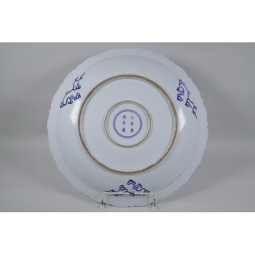 119 - A Chinese blue and white porcelain charger with lobed rim, decorated with two dragons chasing a flam... 