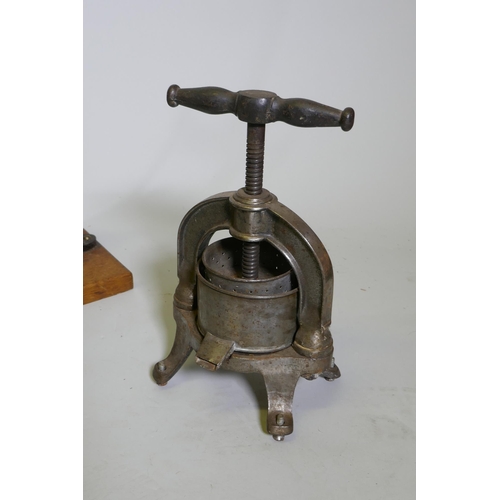 129 - A quantity of vintage kitchenalia, to include a cast metal French fruit/cheese press, a cast iron ma... 