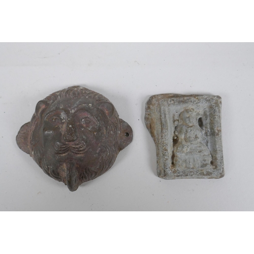 134 - An antique Indian lead filled bronze lion head door mount, and a cast metal Buddha pendant, 6.5cm di... 