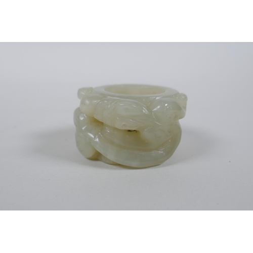 135 - A Chinese grey jade archer's thumb ring with carved dragon decoration, 4.5cm diameter