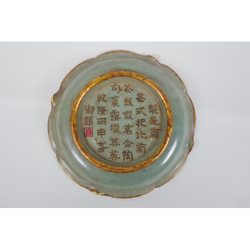 137 - A Chinese celadon glazed porcelain dish with gilt metal lobed rim, chased and gilt character inscrip... 