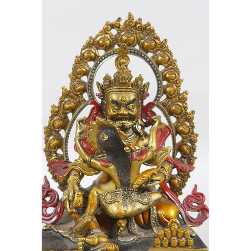 139 - A Tibetan painted and gilt bronze figure of the deity Jambhala, 24cm high