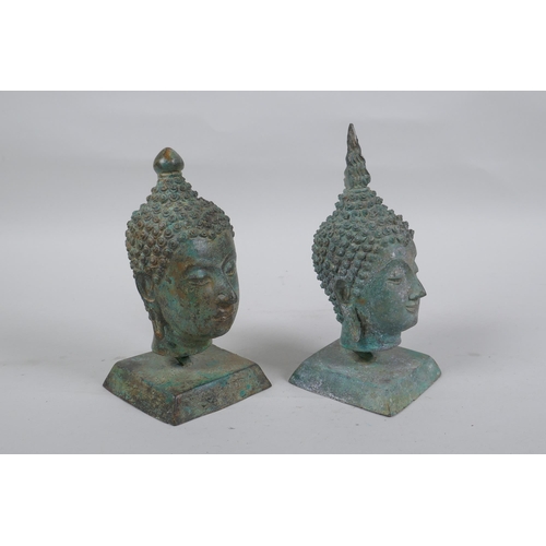 147 - A pair of bronze Buddha's heads with green patina, mounted on a metal stand, 16cm high