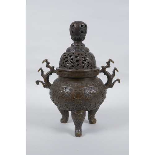 149 - A Chinese bronze censer and cover on tripod supports, with two ruyi shaped handles and allover lotus... 