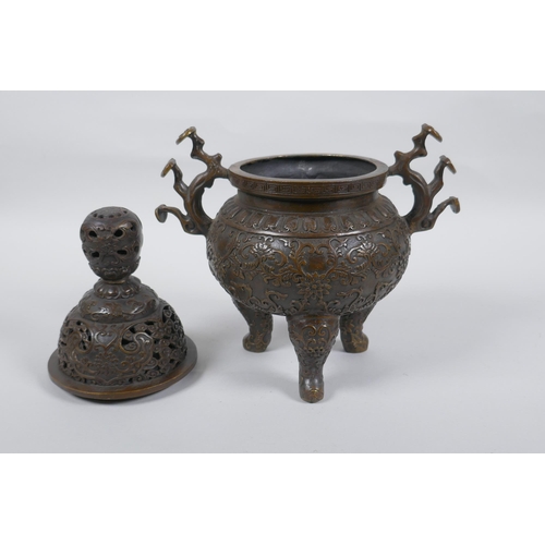 149 - A Chinese bronze censer and cover on tripod supports, with two ruyi shaped handles and allover lotus... 