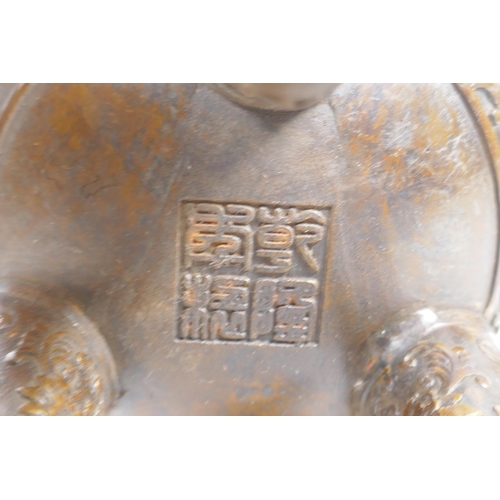 149 - A Chinese bronze censer and cover on tripod supports, with two ruyi shaped handles and allover lotus... 