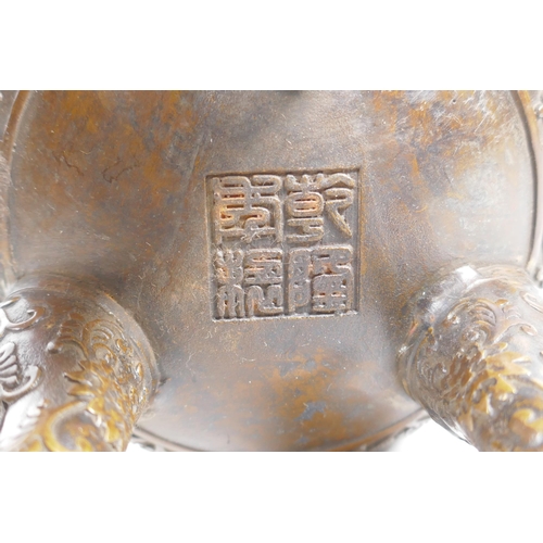 149 - A Chinese bronze censer and cover on tripod supports, with two ruyi shaped handles and allover lotus... 